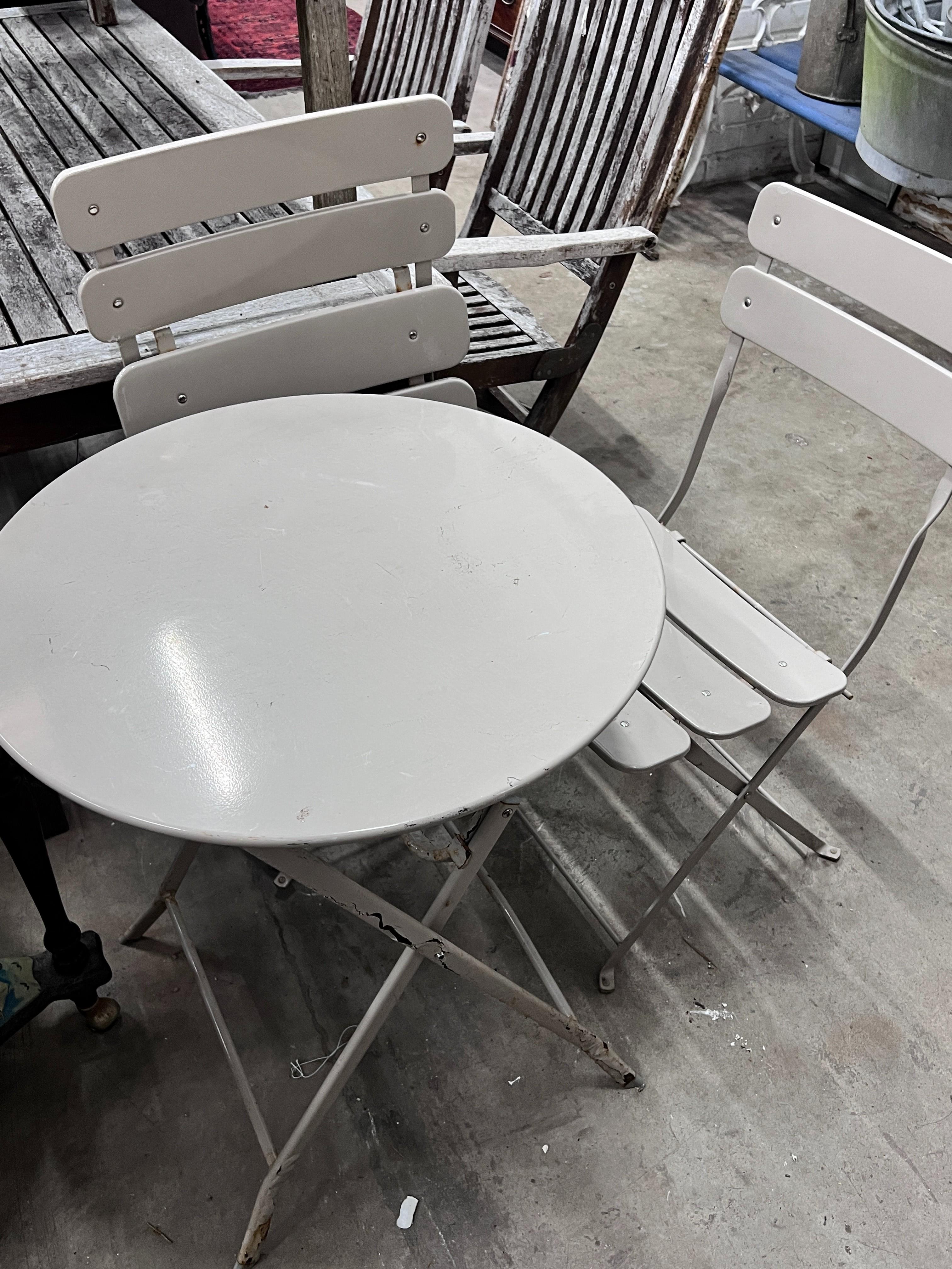 A circular painted metal folding garden table, diameter 60cm, height 71cm and two folding chairs